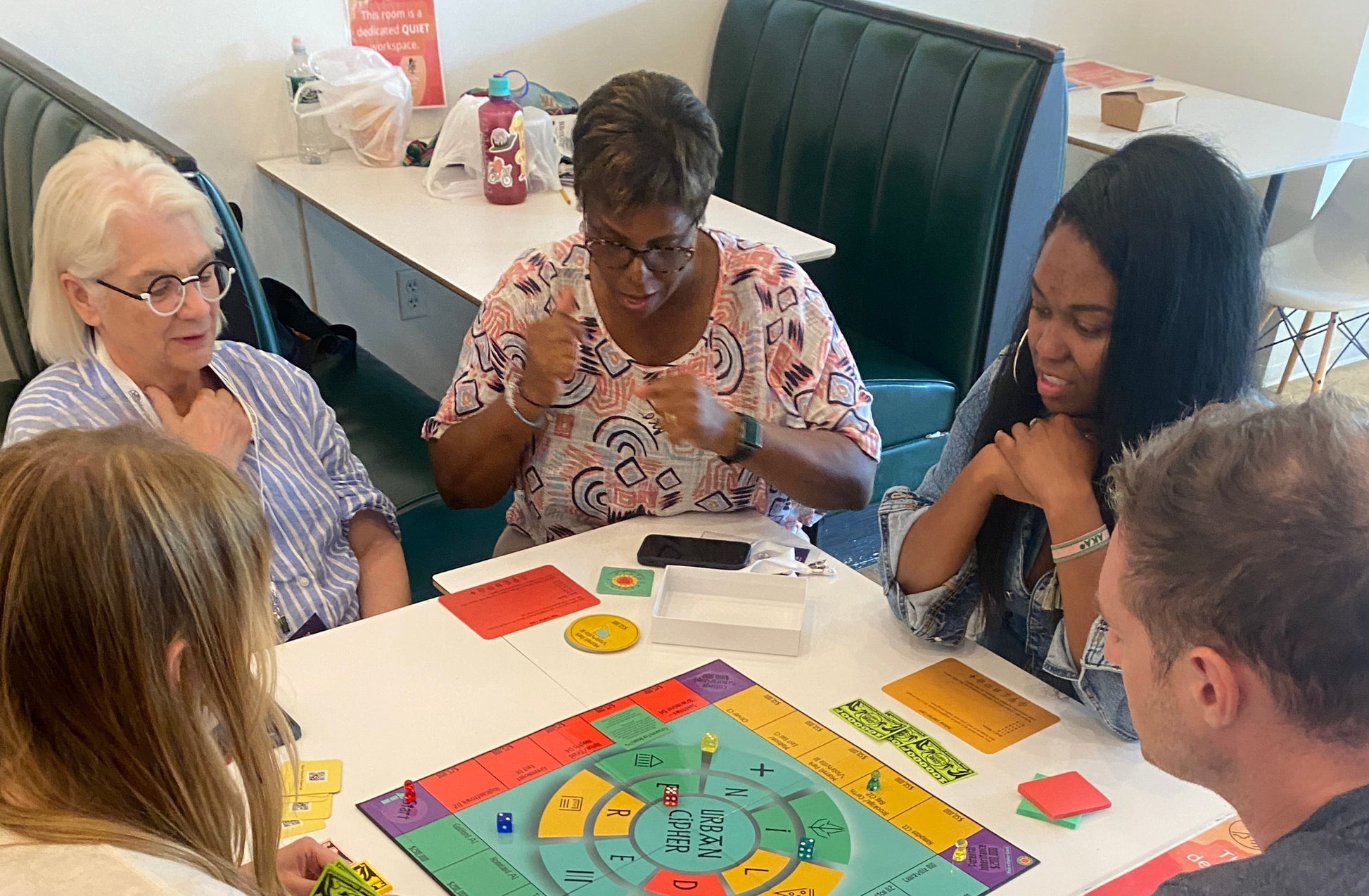 Group of people playing a board game together at a table.